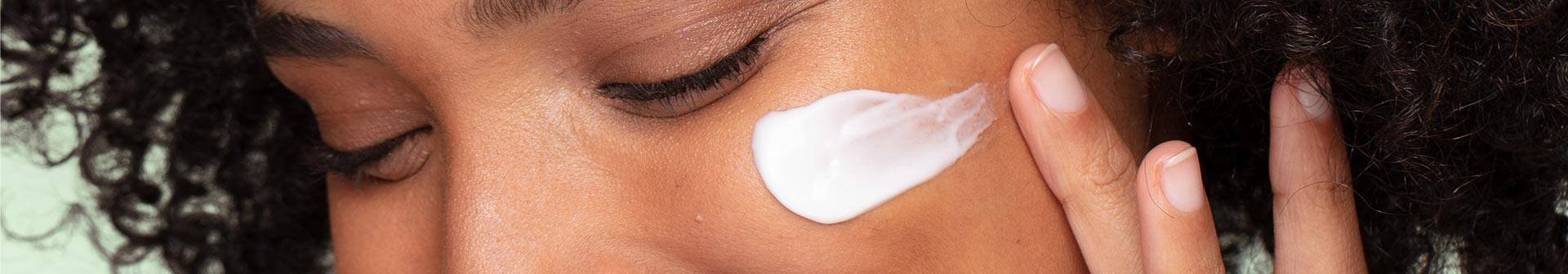 Frau verwendet Augenpflege gegen Tränensäcke