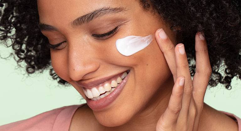 Frau verwendet Augenpflege gegen Tränensäcke