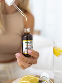 Une femme prélève du sérum dans le flacon à l'aide d'une pipette