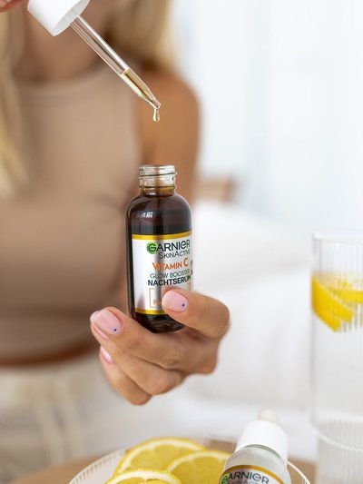 Frau entnimmt Serum mit einer Pipette aus der Flasche