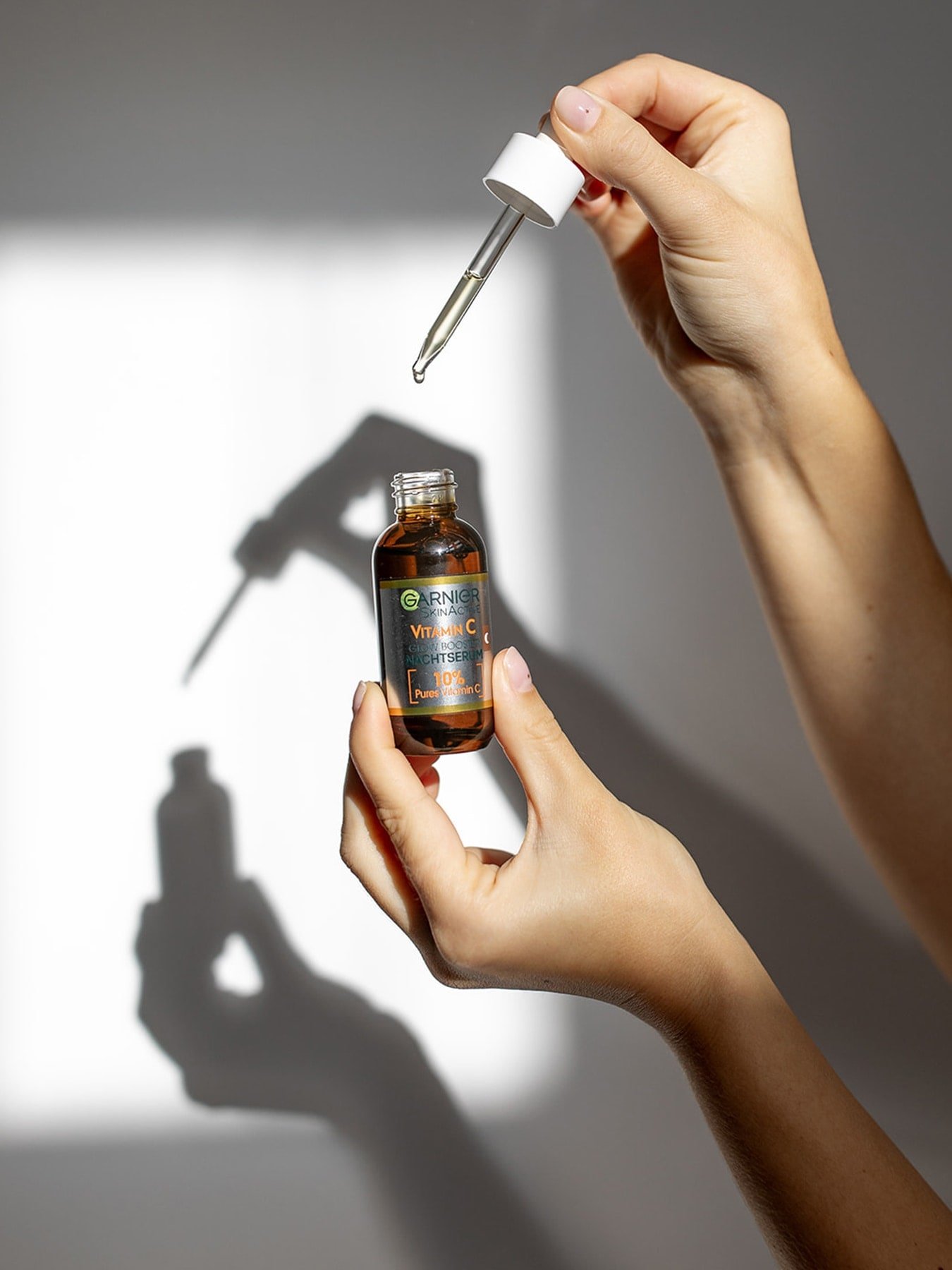 Une personne utilise le sérum de nuit Vitamin C Glowbooster